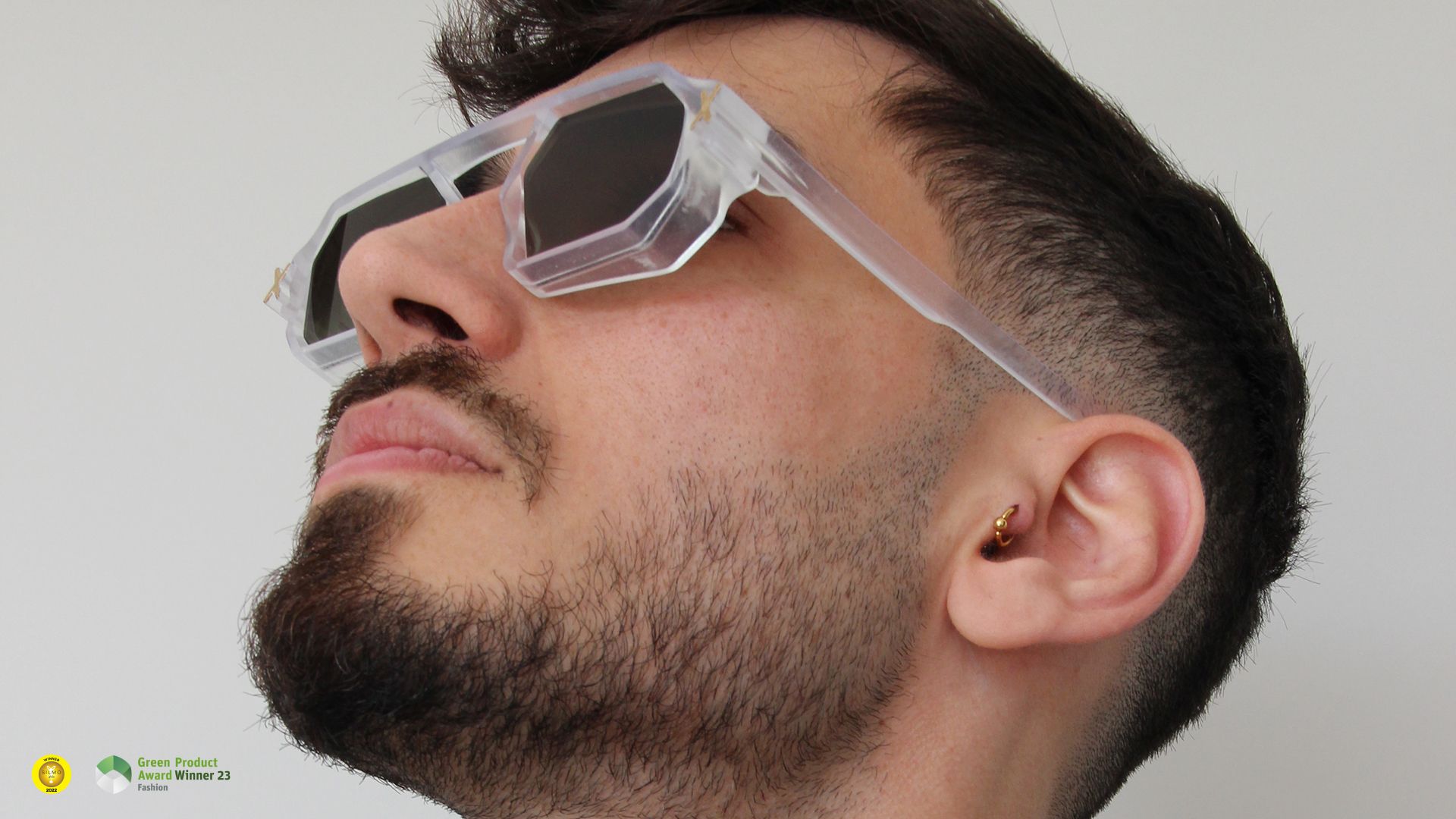A man looking upward wearing translucent Unfoldable sunglasses with tinted lenses.