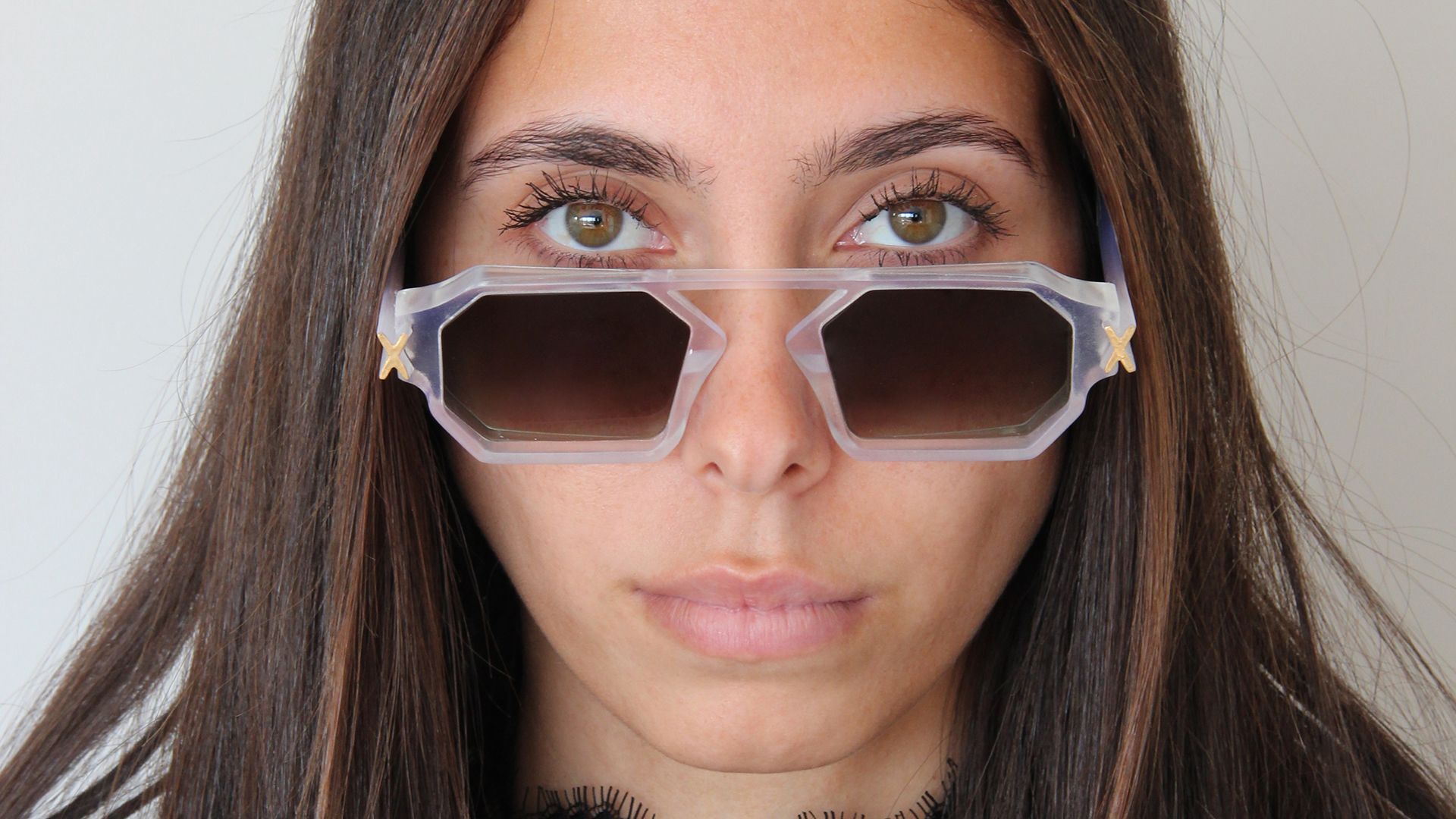Front view of a woman wearing translucent Unfoldable frames with gradient brown lenses.