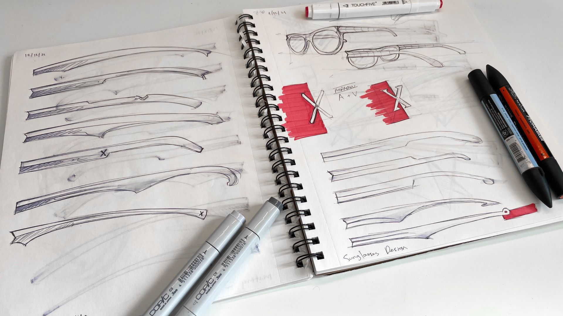Sketchbook of Unfoldable frame studies and red X-connector concepts drawn with markers.