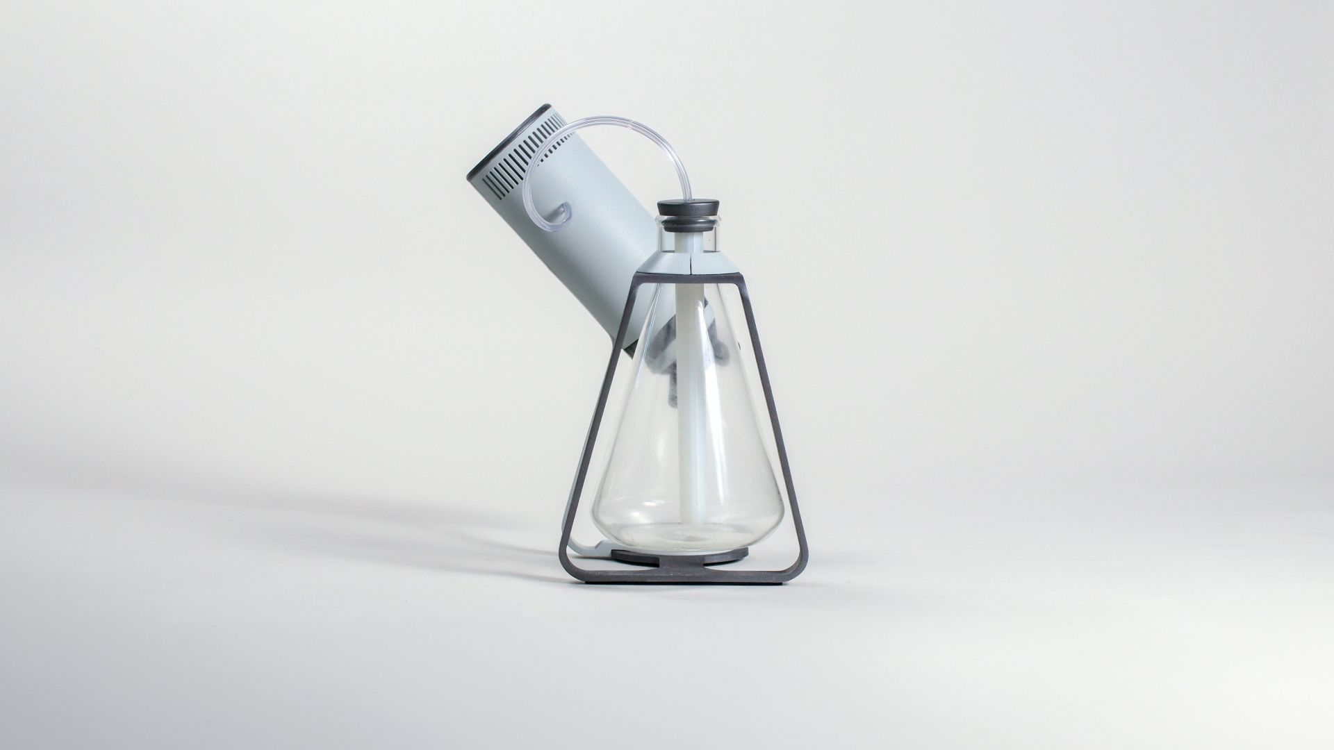 The conical glass flask with the bean cylinder tilted into its pouring position.